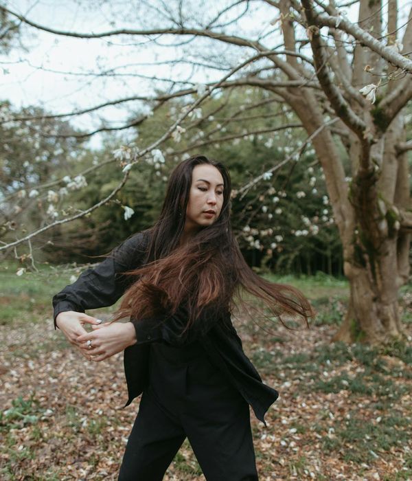Woman performing a fluid, graceful movement in a calm environment.